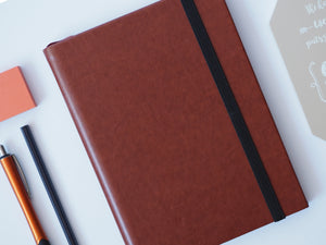 The Paper Saver Reusable Eco Notebook in brown repurposes your paper as its pages so you can write your notes and ideas more sustainably, reducing paper waste and saving the environment.